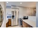 Modern kitchen with white countertops, stainless steel appliances, and hardwood floors at 303 W Lehow Ave # 22, Englewood, CO 80110