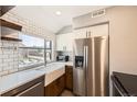 Modern kitchen with subway tile backsplash, farmhouse sink, stainless steel appliances, and hardwood floors at 303 W Lehow Ave # 22, Englewood, CO 80110