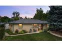 A charming single story brick home, complemented by a lush front lawn and vibrant garden at 1217 Lincoln St, Longmont, CO 80501