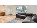 Bright living room featuring hardwood floors, a bay window, and a comfortable, modern sofa at 2692 S Osceola St, Denver, CO 80219