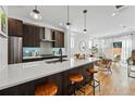 Open kitchen with quartz countertops, stainless steel appliances, and a view into the living room and outdoor patio at 4440 Tennyson St # 4, Denver, CO 80212