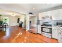 Kitchen with stainless steel appliances that opens into dining and living area with hardwood floors at 19523 E Buchanan Pl, Aurora, CO 80011