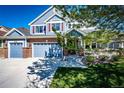 Beautiful two-story blue home with a three-car garage, brick accents, and a well-maintained lawn at 22685 E Calhoun Pl, Aurora, CO 80016
