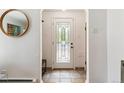 Entryway with tiled floor, a decorative front door, and a stylish round mirror at 1459 S Elizabeth St, Denver, CO 80210