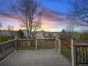 Lovely outdoor wooden back deck overlooking a green backyard during a colorful sunset at 3865 Rawhide Cir, Castle Rock, CO 80104