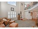Bright living room with high ceilings, a staircase overlook, large windows, and comfortable seating at 3865 Rawhide Cir, Castle Rock, CO 80104