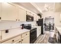 Bright kitchen with white cabinets, black appliances, and an adjacent dining area at 7865 E Mississippi Ave # 602, Denver, CO 80247