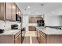 Spacious kitchen featuring stone countertops, ample cabinetry, and modern appliances at 9635 Bellaire Ln, Thornton, CO 80229
