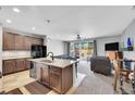 Open-concept kitchen featuring granite countertops, dark wood cabinets, and seamless flow to the living area at 9635 Bellaire Ln, Thornton, CO 80229