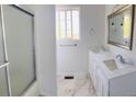 Bright bathroom featuring double sinks, marble floors, and a glass-enclosed shower at 12225 E 2Nd Dr, Aurora, CO 80011