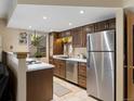 This kitchen features warm wood cabinets, tile floor, stainless steel appliances, and a window for natural light at 12476 W Nevada Pl # 106, Lakewood, CO 80228