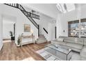Bright living room with wood floors, a modern staircase, and a comfortable seating area at 16332 Bluebell Pl, Parker, CO 80134