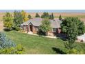 Beautiful aerial view of a well-kept brick home with an expansive green lawn at 18399 Wagon Trl, Mead, CO 80542