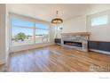 Spacious living room with a fireplace, large windows, hardwood floors, and recessed lighting at 2305 Glacier Ct, Lafayette, CO 80026