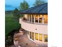 Unique exterior with rounded balconies, warm lighting, stone pathway, and lush green surroundings at twilight at 640 S 68Th St, Boulder, CO 80303