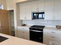 Chef's kitchen features stainless steel appliances, a gas range, and pristine white cabinets at 733 Kubat Ln # B, Longmont, CO 80503