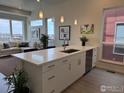 Bright, open kitchen featuring an island with quartz countertops, pendant lighting and stainless steel appliances at 733 Kubat Ln # B, Longmont, CO 80503