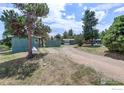 Exterior view of the home showing the driveway, garage, and surrounding wooded landscape at 107 Deer Trail Rd, Boulder, CO 80302
