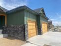 A three-car garage and green siding provide character for this lovely new home at 1366 Eliza Ave, Berthoud, CO 80513