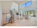 Bright living room featuring a cozy fireplace, modern furnishings and a grand staircase at 923 Saint Andrews Ln, Louisville, CO 80027