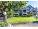 Well-maintained condo building with lush lawn, mature tree, and manicured landscaping at 2850 Aurora Ave # 112, Boulder, CO 80303