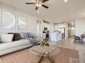 Open-concept living room flowing into a kitchen with modern decor, neutral tones, and ample natural light at 776 Griffith St, Lochbuie, CO 80603