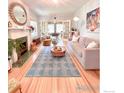 Bright living room with hardwood floors, decorative fireplace, and an open layout into another room at 1515 E 8Th Ave # 1, Denver, CO 80218