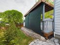 Backyard with a covered deck and privacy screen, landscaped garden and retaining wall at 2720 E 121St Pl, Thornton, CO 80241