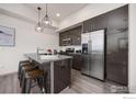 Modern kitchen features stainless steel appliances, stylish gray cabinets, and a breakfast bar with seating at 2445 Junction Pl # 206, Boulder, CO 80301