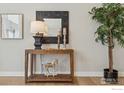 Elegant interior featuring a wooden console table with decorative accents and a lush potted plant at 1361 Art Dr, Berthoud, CO 80513