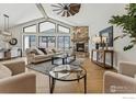 Spacious living room with vaulted ceilings, a stone fireplace, and large windows offering plenty of natural light at 1361 Art Dr, Berthoud, CO 80513