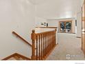 View of staircase leading to main level with wood railing and tiled flooring at 1633 Francis Way, Longmont, CO 80501