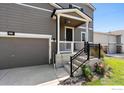 Two-story house with gray siding, a covered porch, and a two-car garage at 6112 Black Mesa Rd, Frederick, CO 80516