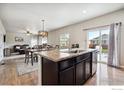 Open kitchen with island, stainless steel appliances, and hardwood floors at 6112 Black Mesa Rd, Frederick, CO 80516