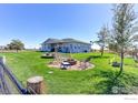 Large grassy backyard featuring a firepit, swing, and space for outdoor activities, perfect for entertaining at 11499 County Road 40.5, Platteville, CO 80651