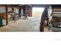 Garage featuring ATV, boat, tool cabinets and large open bay door at 11499 County Road 40.5, Platteville, CO 80651