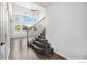 Bright entryway with elegant staircase and hardwood floors at 6850 Sage Ave, Firestone, CO 80504