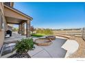 An inviting outdoor patio includes a fire pit and a built in bench, perfect for entertaining and relaxation at 775 Longs Peak Dr, Erie, CO 80516