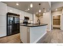 Bright kitchen with a dark countertop island, stainless steel appliances, and open access to a bathroom at 265 High Point Dr # 203, Longmont, CO 80504