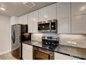 Close up of the kitchen with stainless steel appliances, white cabinets and mosaic backsplash at 265 High Point Dr # 203, Longmont, CO 80504
