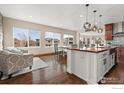 Bright open kitchen featuring a large island with seating and pendant lighting at 2841 Ironwood Cir, Erie, CO 80516