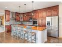 Beautiful kitchen with custom wood cabinets, island with seating and stainless steel appliances at 2841 Ironwood Cir, Erie, CO 80516