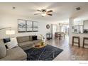Open-concept living room and dining area with modern furnishings, hardwood floors, and neutral decor at 3674 Dexter St, Denver, CO 80207