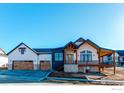 Beautiful two-story home showcasing a blend of modern design with stone accents, a charming porch and three car garage at 1385 Art Dr, Berthoud, CO 80513