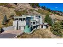 Modern home with three-car garage on a hill, offering unique curved walls and multiple balconies at 230 S Cedar Brook Rd, Boulder, CO 80304