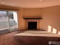 Bright living room featuring a cozy fireplace and sliding glass door to balcony at 4658 White Rock Cir # 5, Boulder, CO 80301