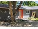 Mid-century modern home with orange door and landscaping at 7705 Baseline Rd, Boulder, CO 80303