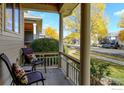 Front porch with two chairs and view of a tree-lined street at 1463 Moonlight Dr, Longmont, CO 80504
