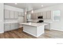 Modern kitchen with gray cabinets, white countertops, and an island at 16850 Mckay Dr, Mead, CO 80542