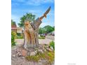 Eye-catching yard art showcasing intricate carvings of animals and nature scenes in a tree trunk at 1638 Meeker Dr, Longmont, CO 80504